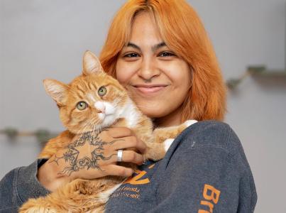 woman holding orange cat