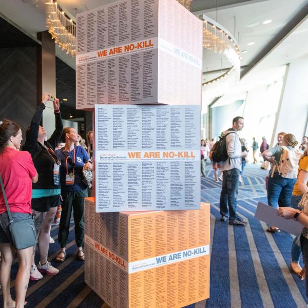Conference attendees look for their organization listed on the ‘We Are No-Kill’ display in Houston, 2023.