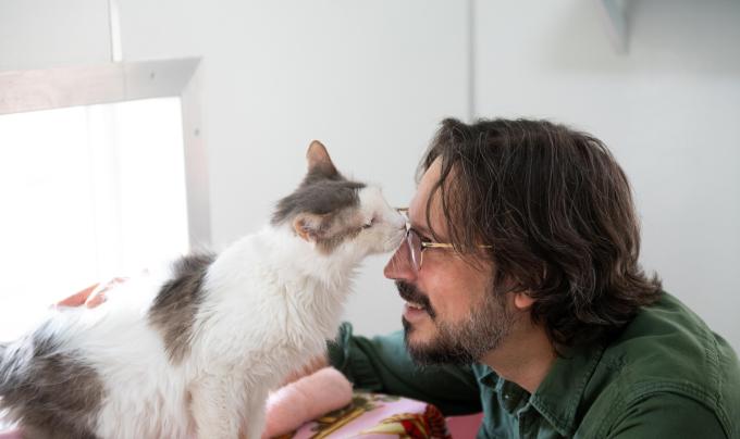 Bubba the cat sniffing Jesse the caregiver's face