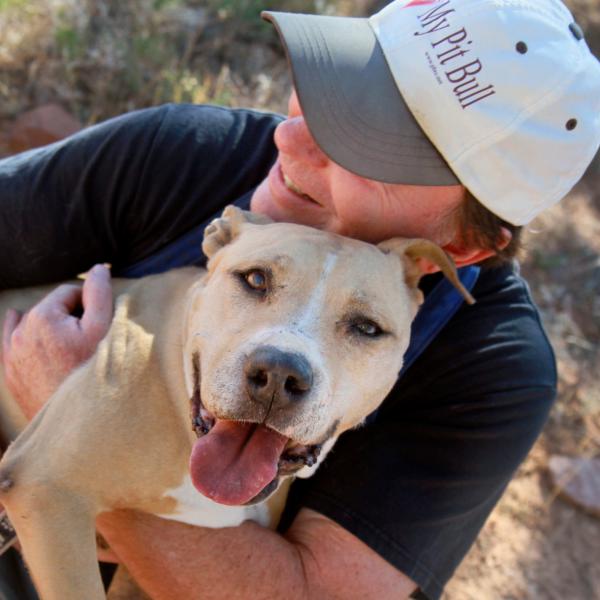 Best Friends employee hugging Ellen the Victory dog