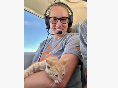 Amy holding the orange kitten in the plane
