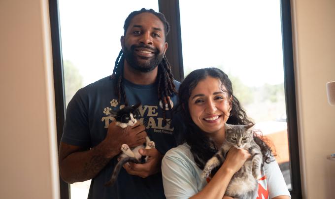 Abdul and Shamiyan holding kittens in front of a window