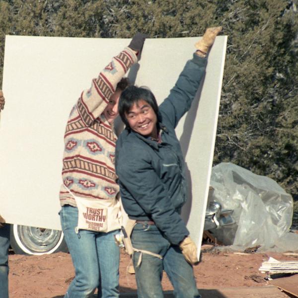 Co-Founders Antony Gleeson and Steven Hirano, with Jason Smith, carry drywall to an in-progress Angel Village. 1985