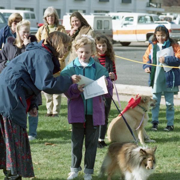 Co-founder Anne Mejia awards a certificate and prize to a Strut Your Mutt participant, 1994.
