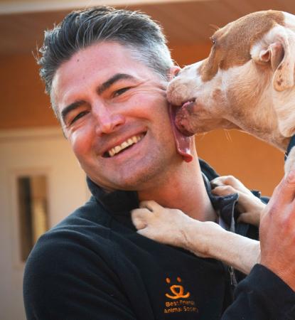 dog licking face of smiling man