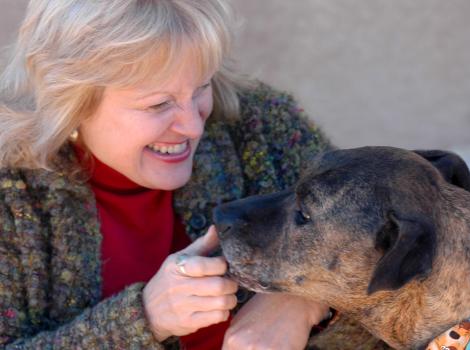 Ledy VanKavage smiling and interacting with a dog