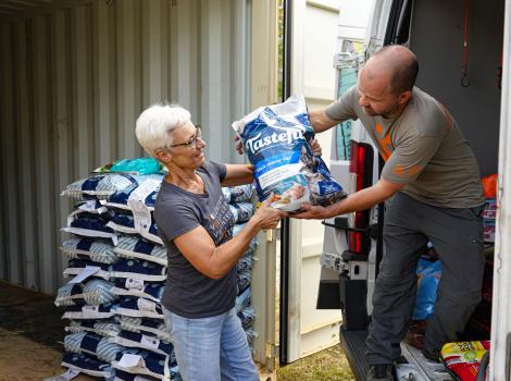 Volunteer Toni Dorsey and another person unloading pet food from a truck