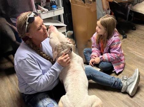Melissa “Missy” Kidwell and child sitting on the floor with a dog