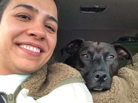 Geoffrey's wife in a vehicle with Pepper the dog looking over from the back seat