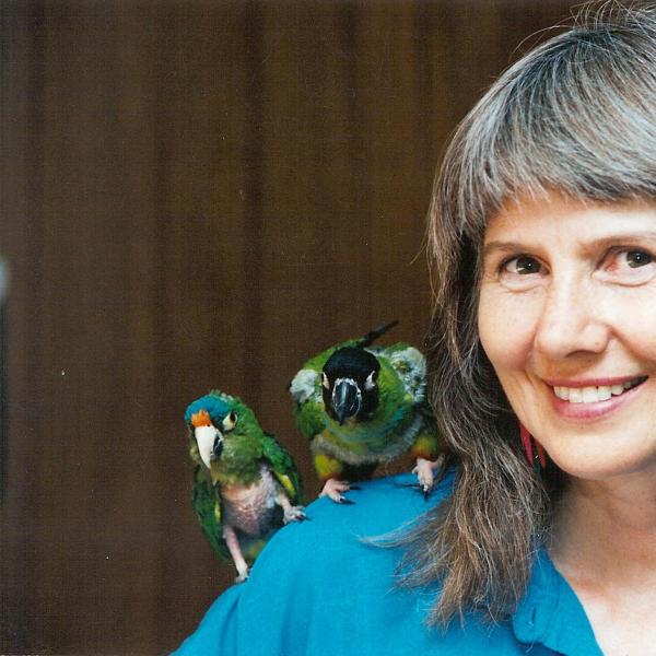 Co-founder Sharon St. Joan poses with two conure friends Fredrico and Calla.