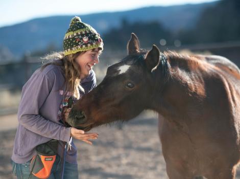 Shy DeLand playing hide-and-seek with Clint the horse