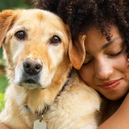 Person laying in grass with dog