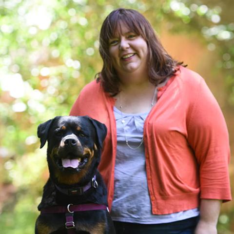 Sue Citro standing next to large black dog outside