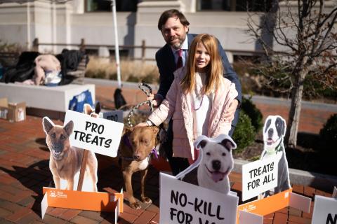 Father and daughter standing with their dog and holding signs advocating for no-kill 