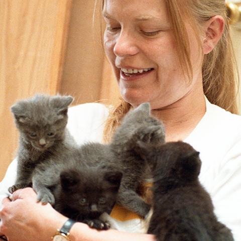 Vivian Ebbs holding a litter of kittens